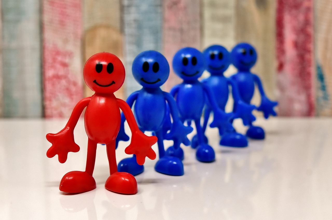 Rotes und 4 blaue Smiles-Figuren hintereinander